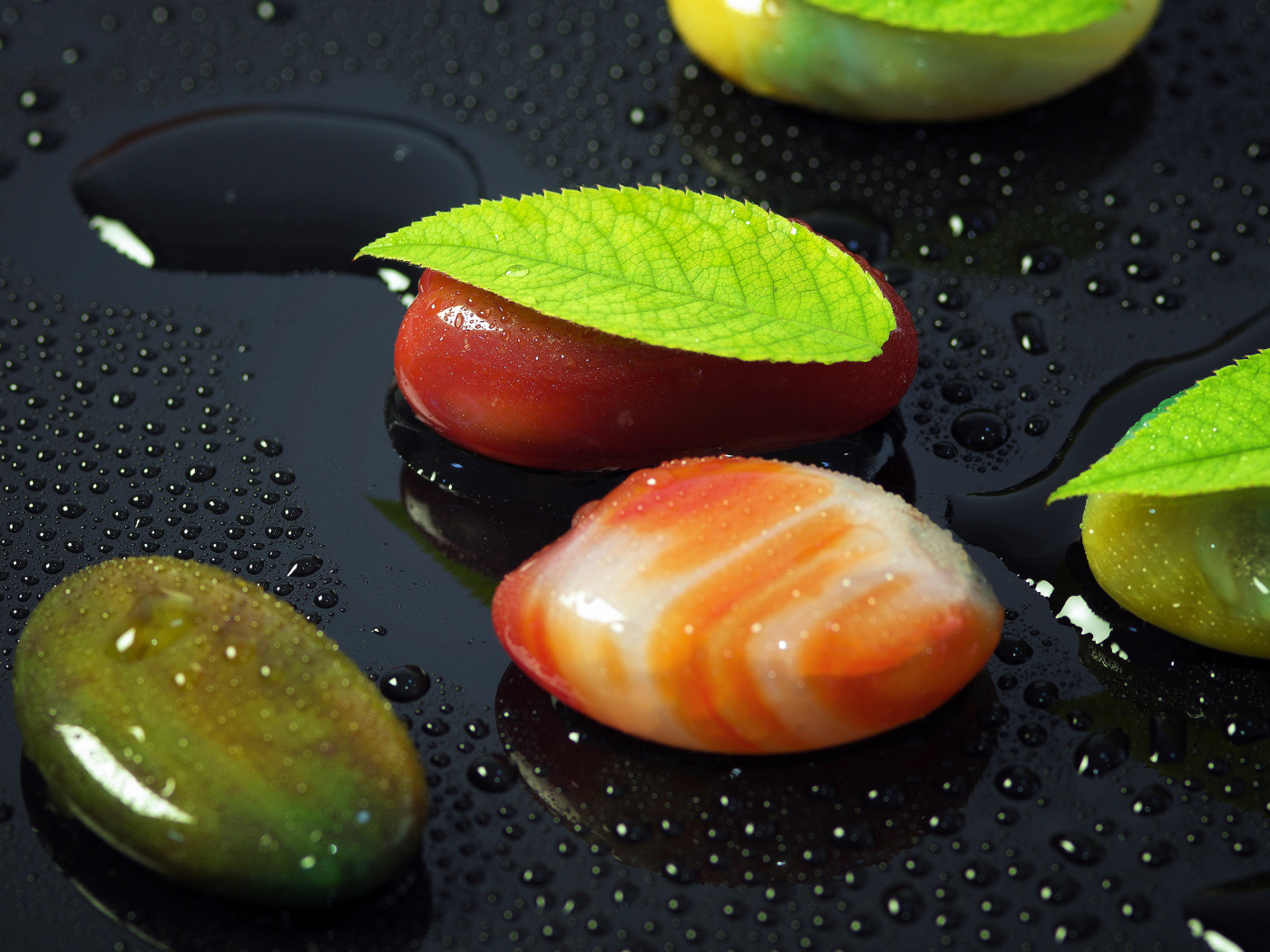 Красивые камни на черной мокрой поверхности