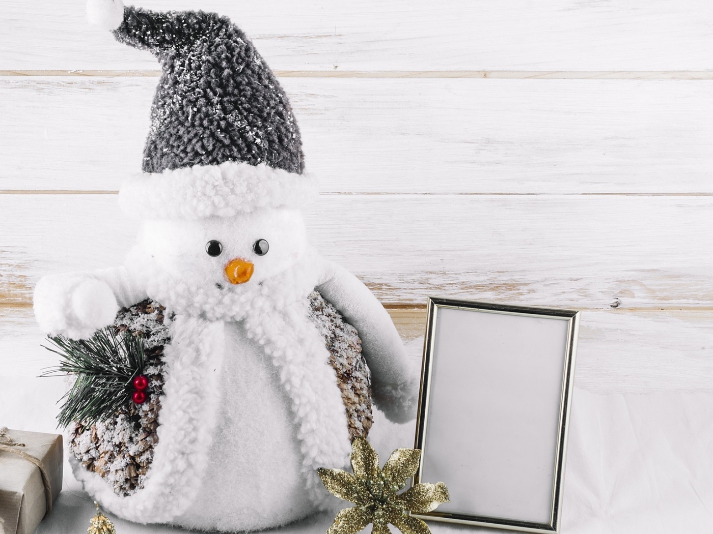 Большой игрушечный снеговик на деревянном фоне