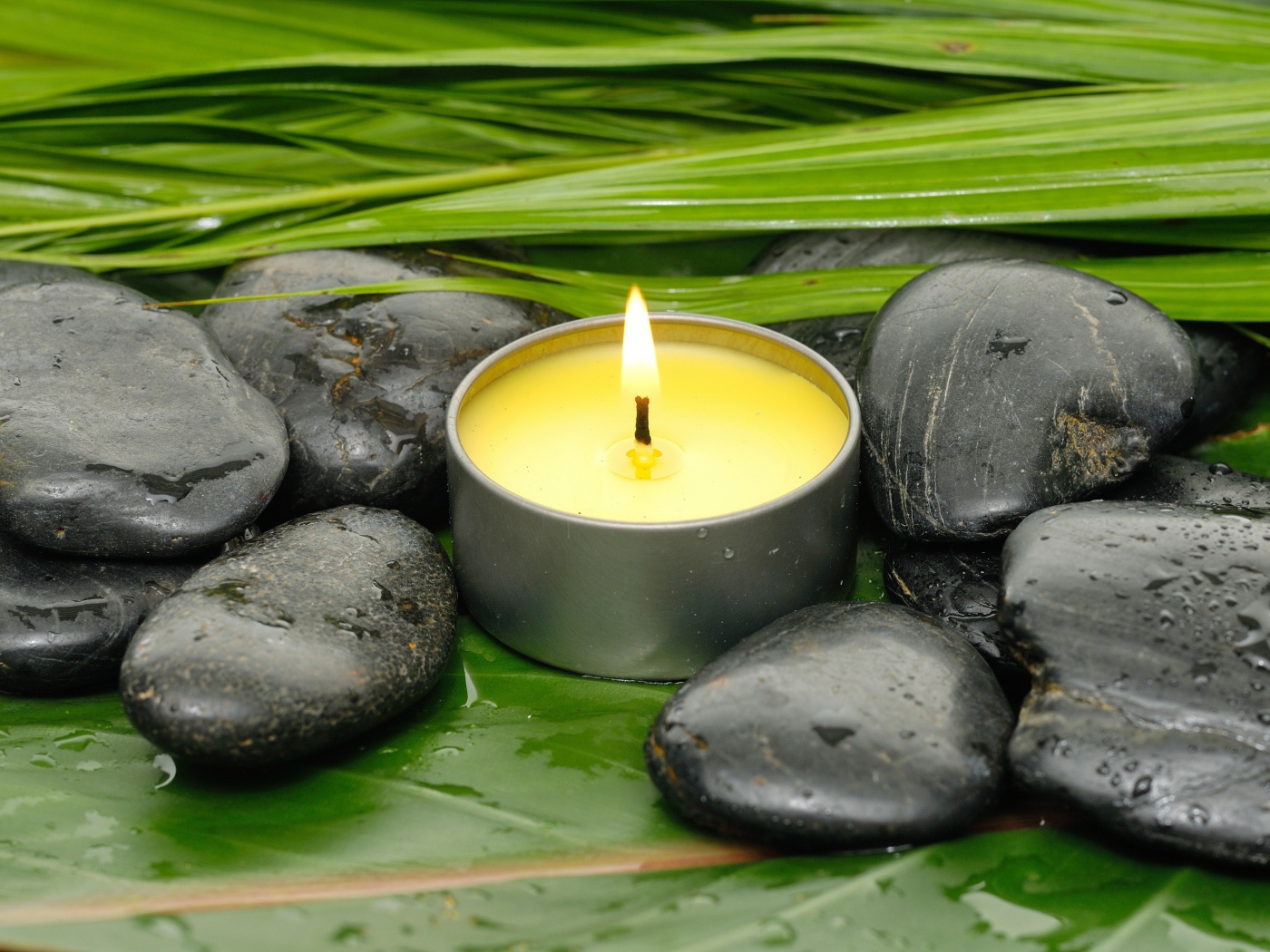 Зажженная свеча и черные камни для SPA