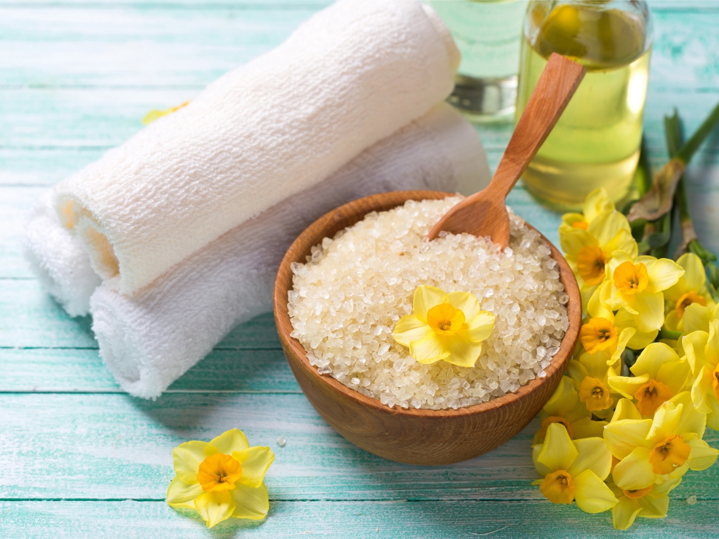 Соль с цветами нарцисса и полотенцем на столе