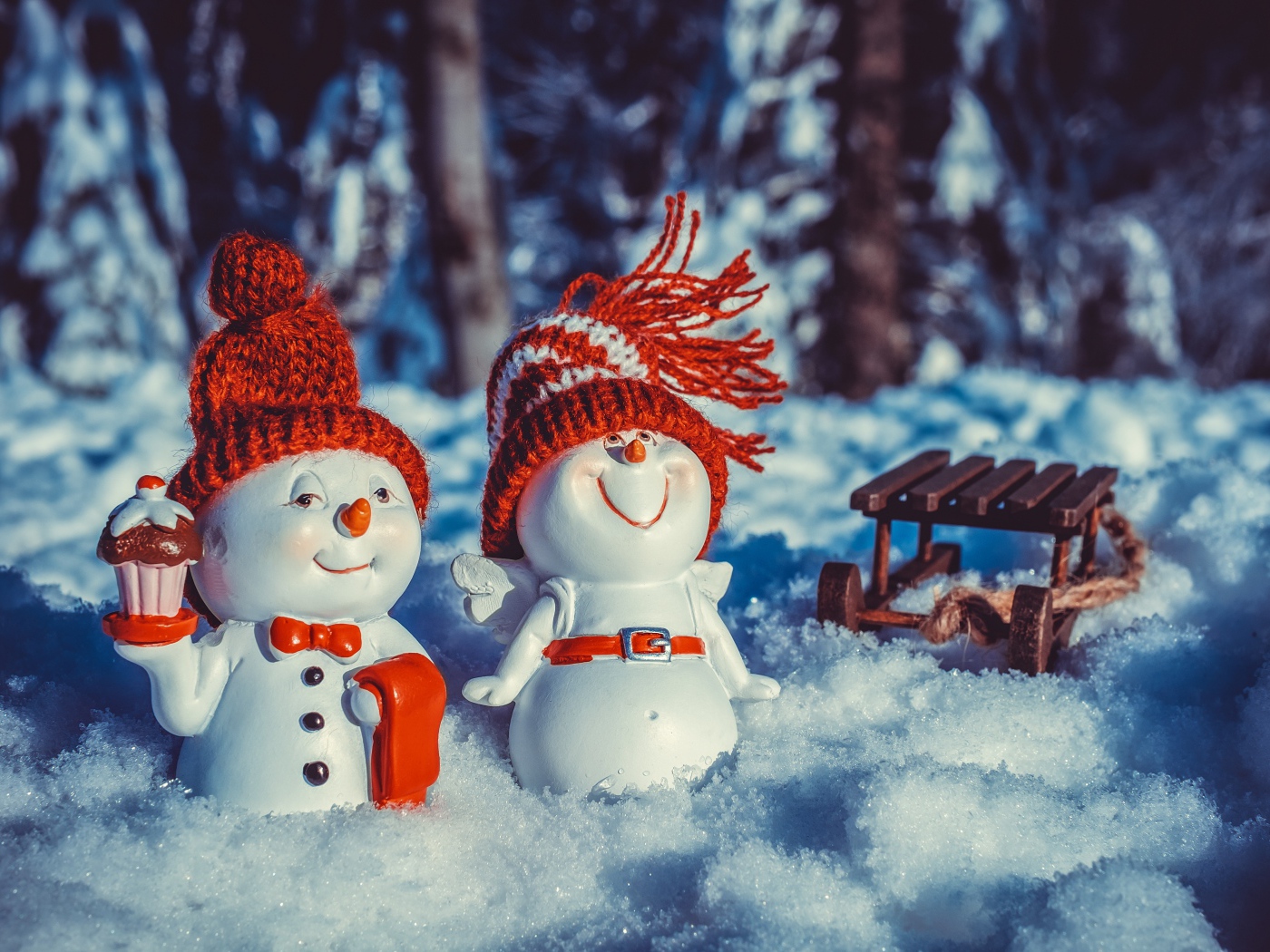 Две статуэтки снеговиков на снегу