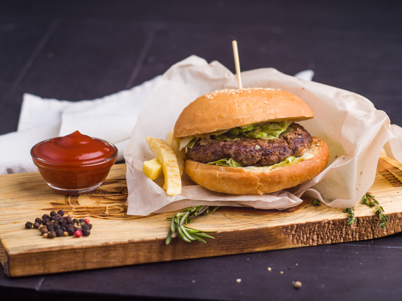 Аппетитный гамбургер с картофелем фри и кетчупом на столе