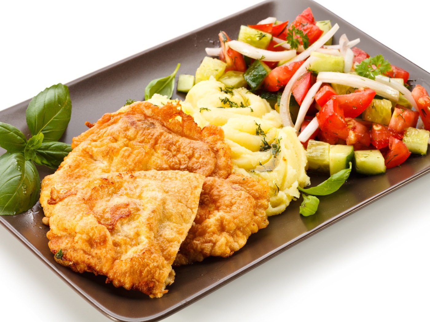 Отбивные с пюре и овощным салатом на тарелке