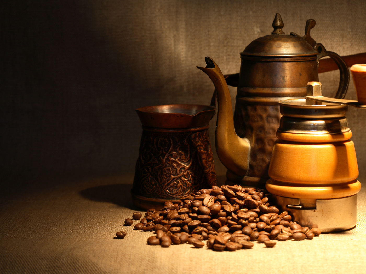 Кофемолка, турка, чайник и кофейные зерна на столе