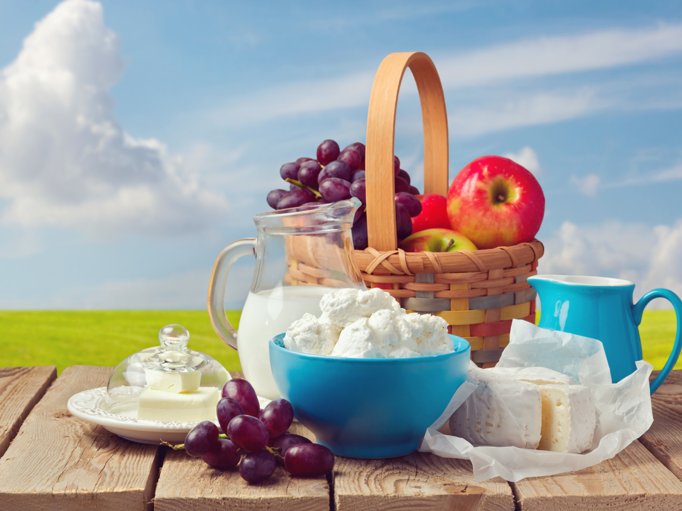 Творог с молоком на столе с виноградом и яблоками 