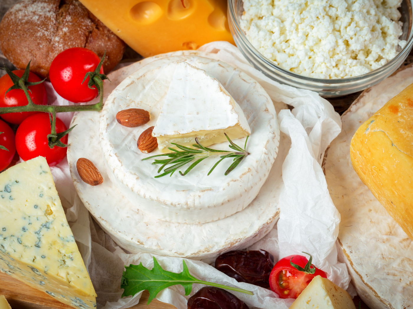 Разные виды сыра на столе с помидорами 