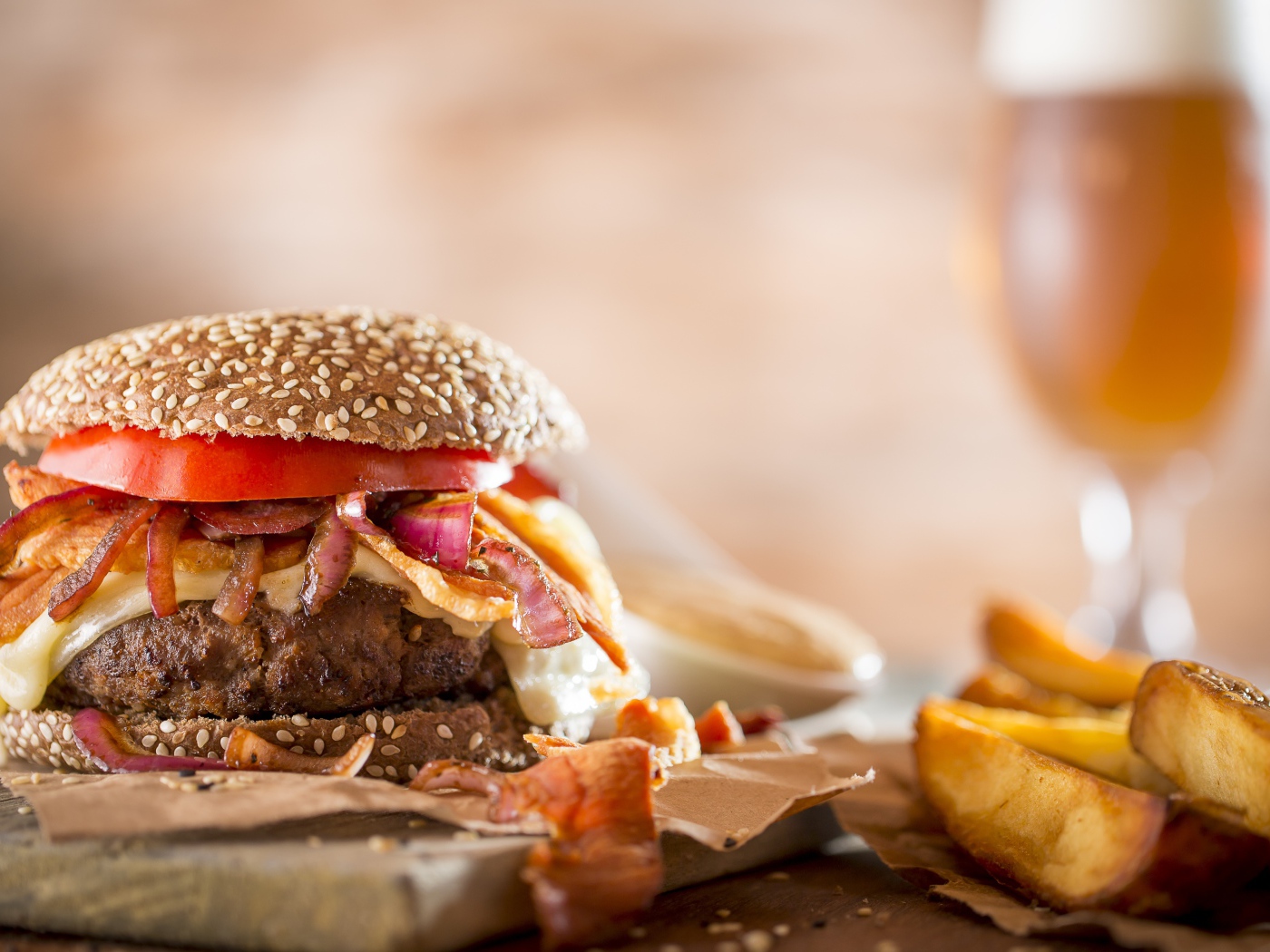 Гамбургер на столе с картофелем и бокалом пива