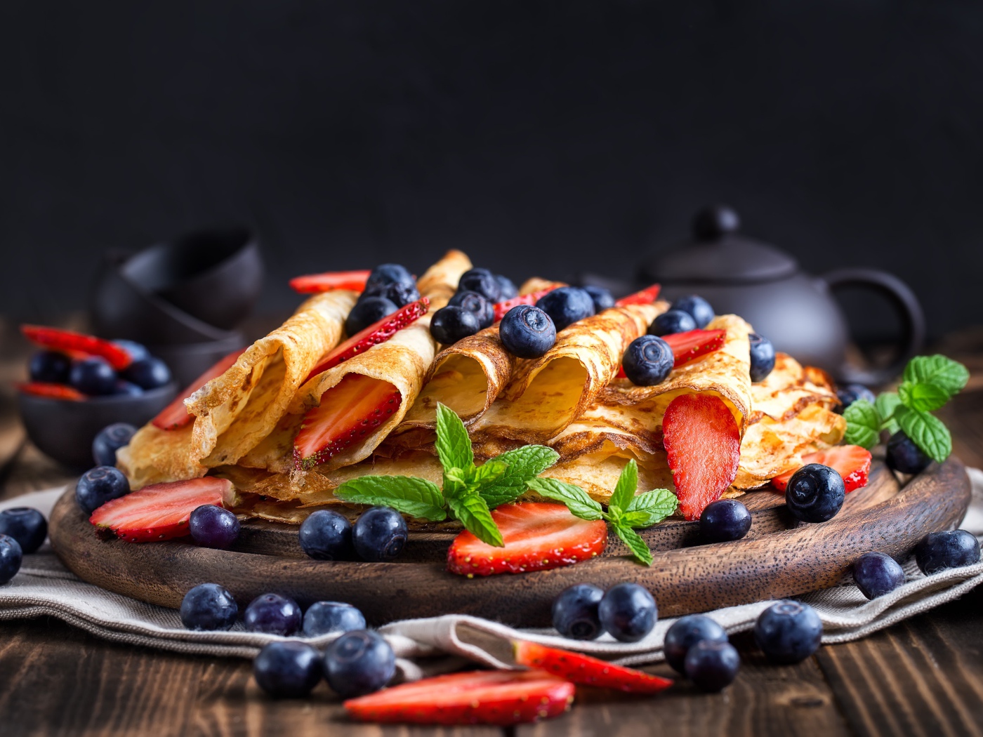 Блинчики с ягодами черники и клубники на столе