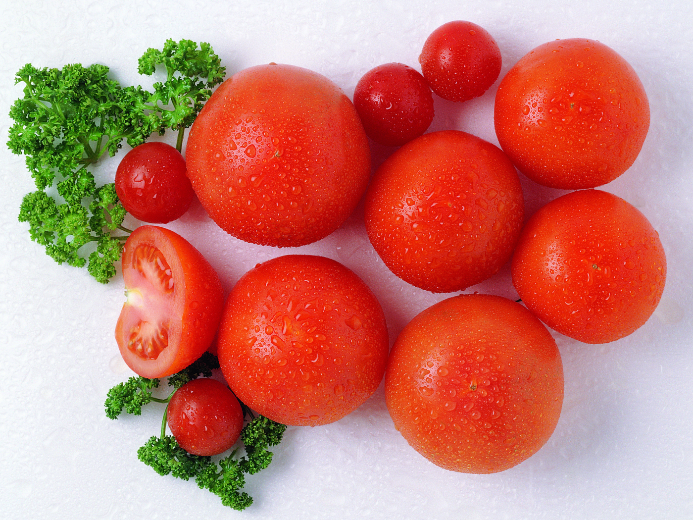 Ripe red tomatoes with parsley in drops of water