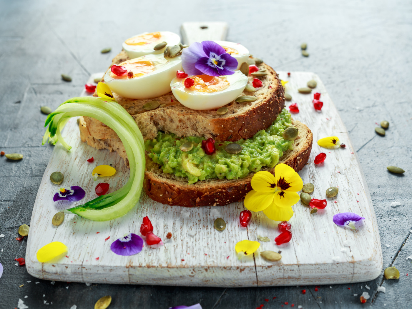 Сендвич с яйцом и цветами на доске