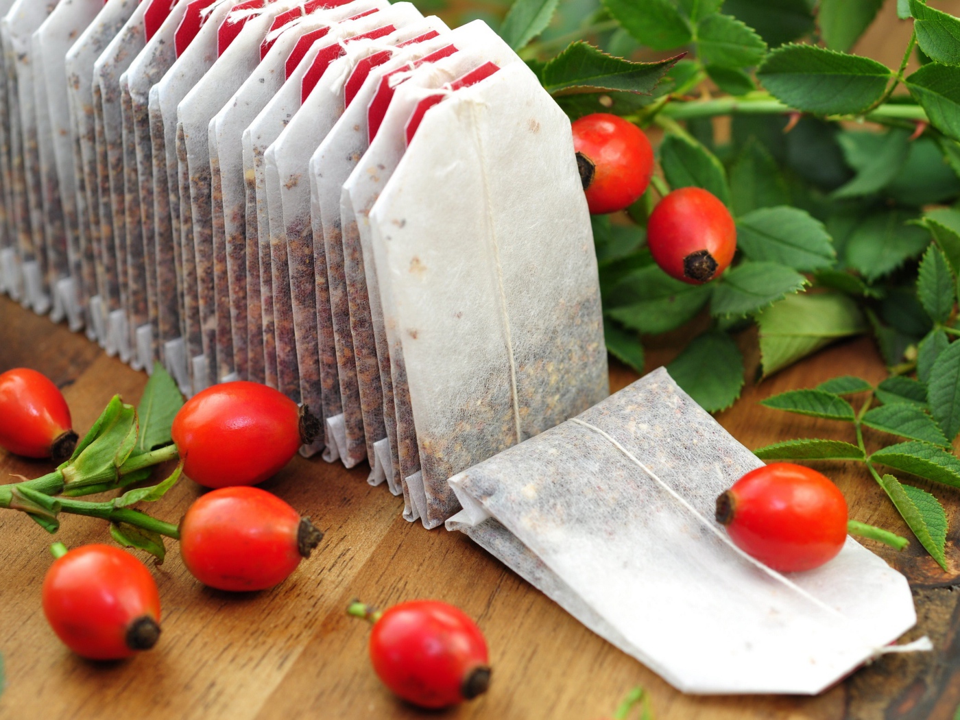 Чай в пакетиках на столе с ягодами шиповника 