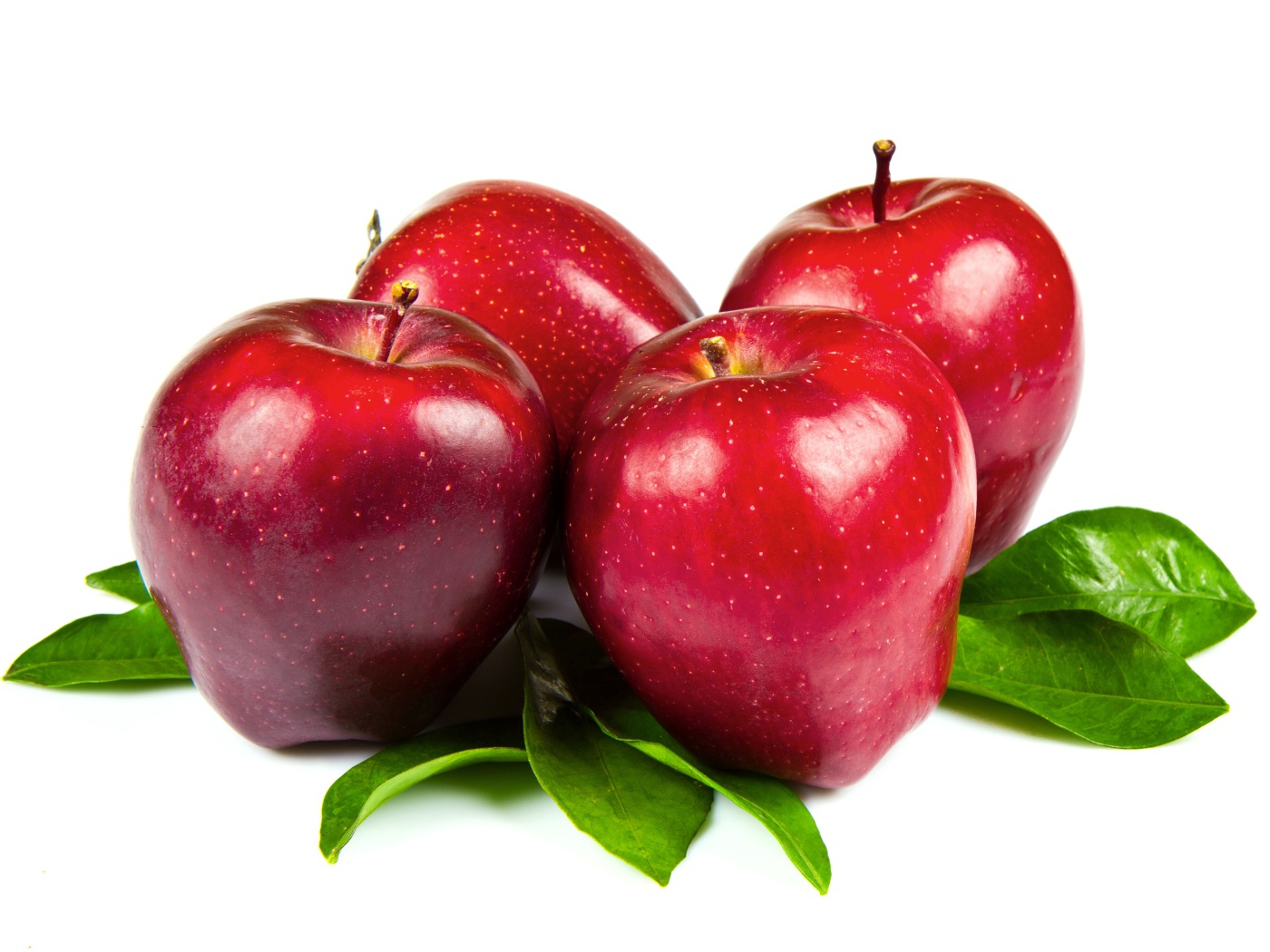 Красивые красные яблоки с зелеными листьями на белом фоне