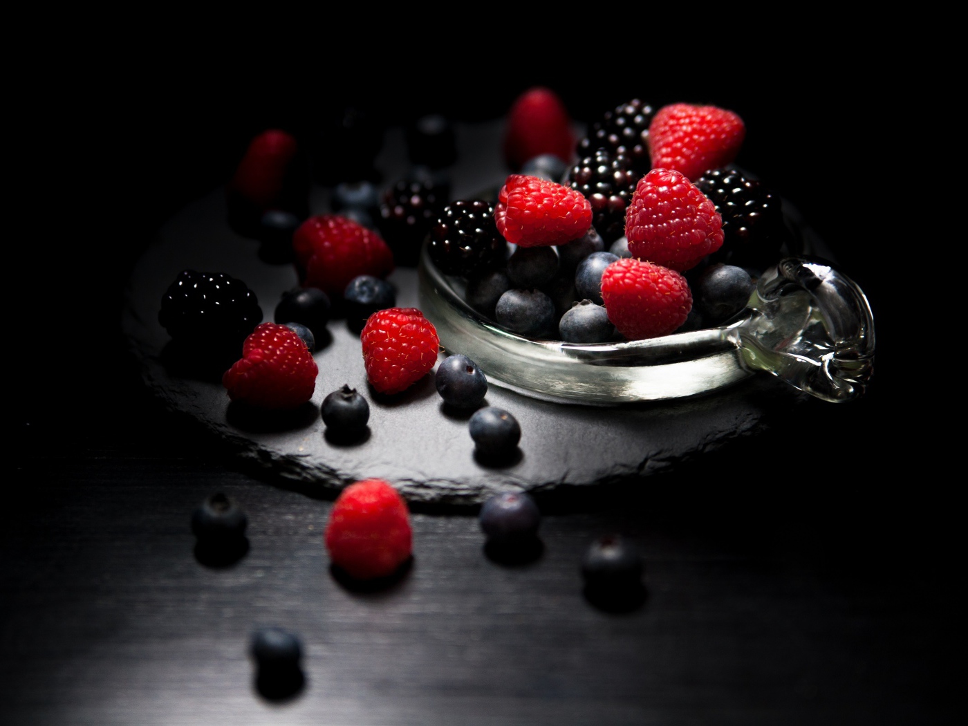 Ягоды черники, малины и ежевики на черном фоне