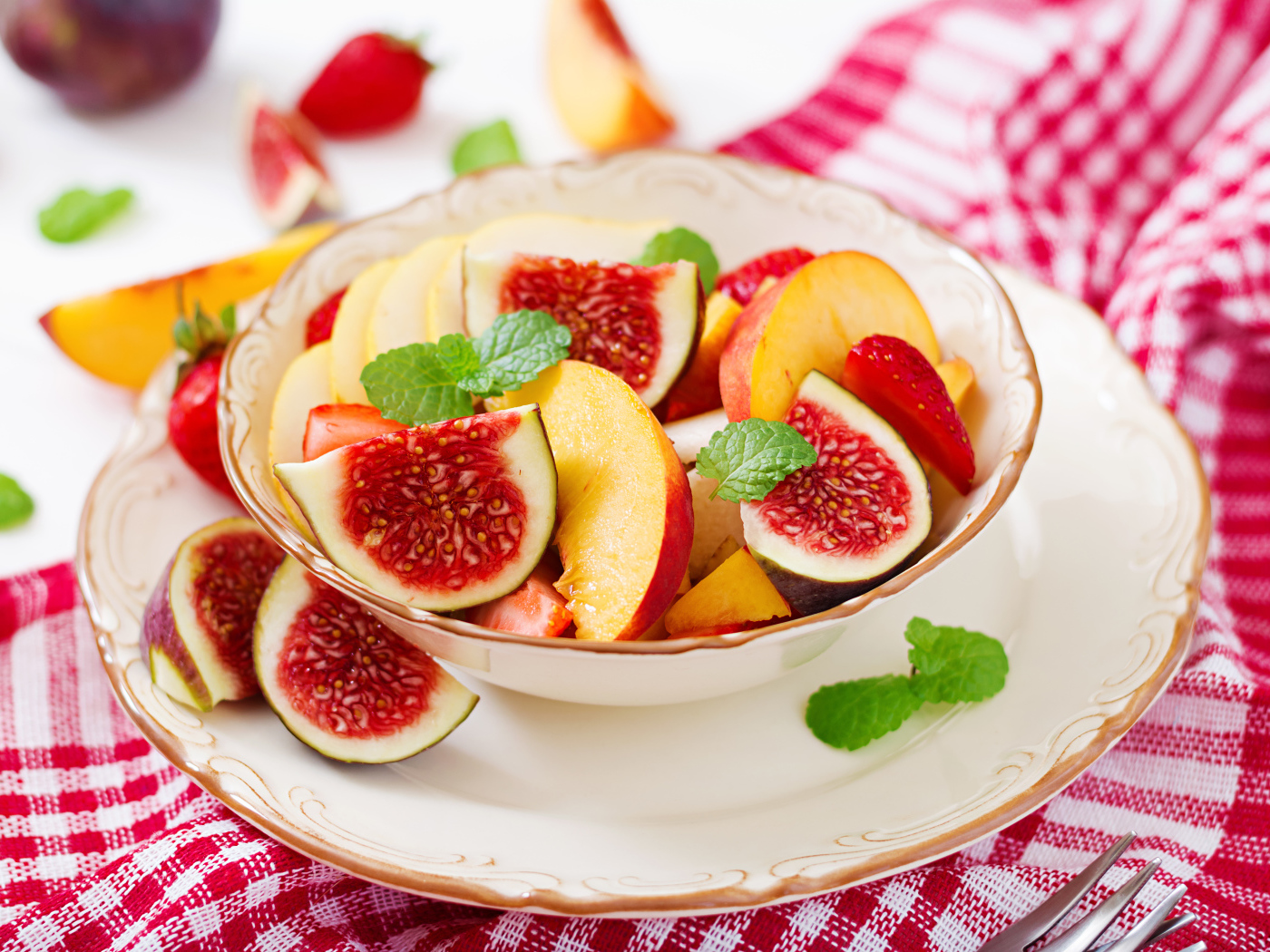 Свежие кусочки инжира и яблока в тарелке на столе