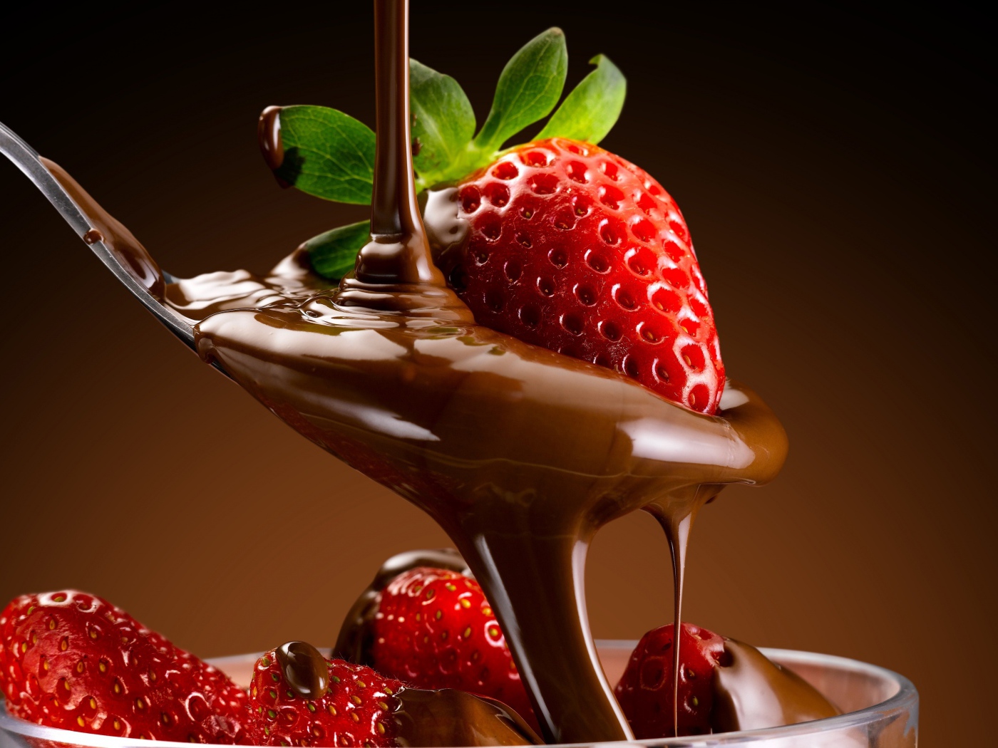 Свежая красная клубника на ложке с шоколадной пастой