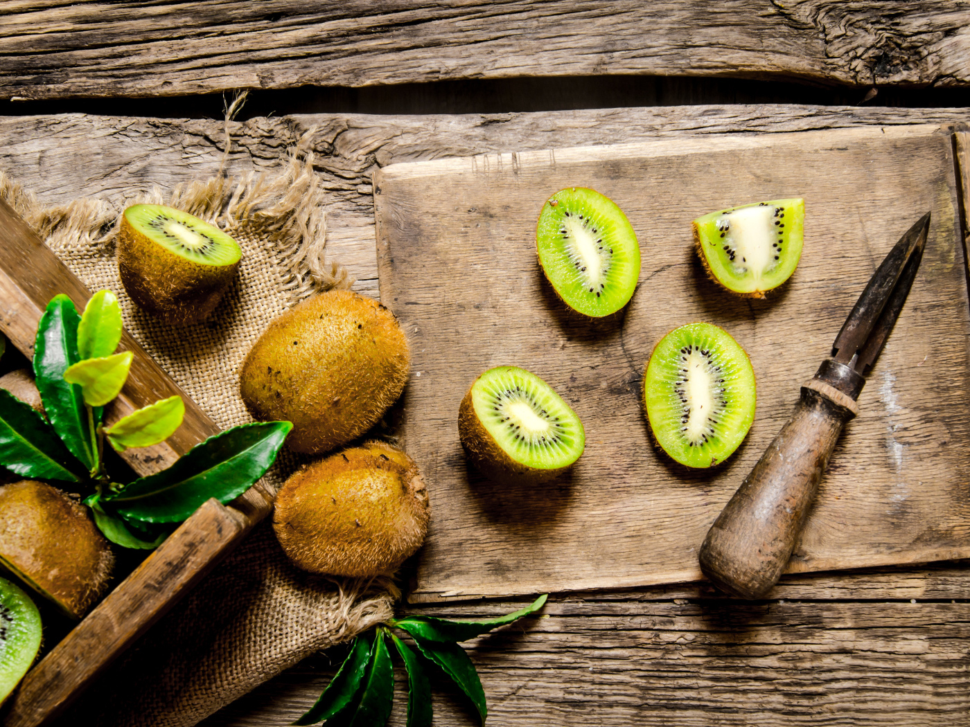 Нарезанное киви на разделочной доске с ножом