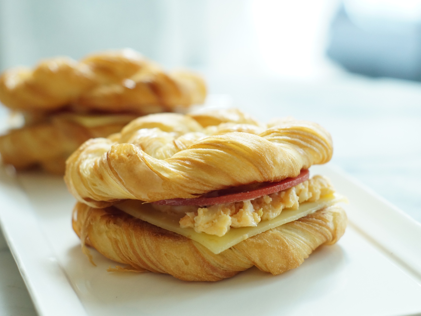 Две булочки с сыром и колбасой на столе