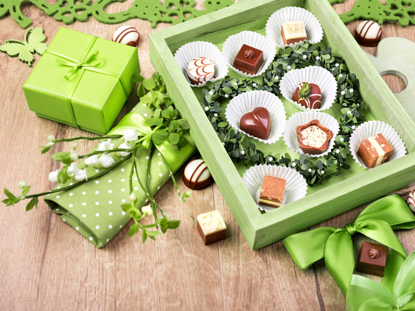 Коробка шоколадных конфет с подарком на столе