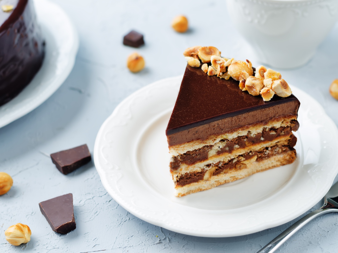 Кусок аппетитного торта с орехами на белой тарелке