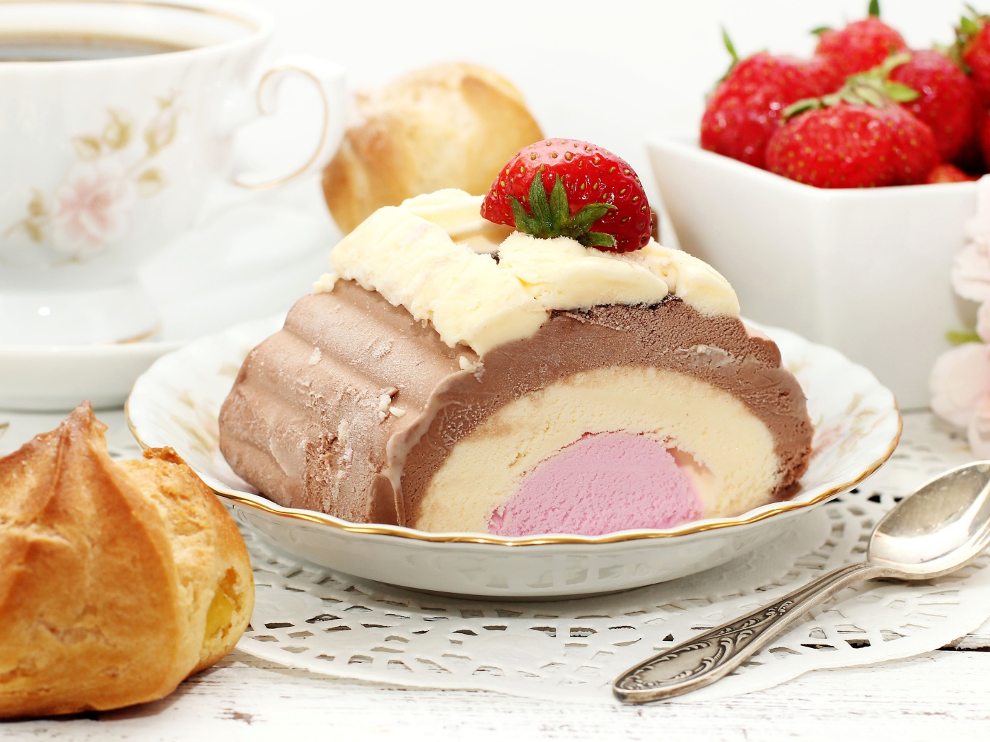 Appetizing ice cream on the table with eclair and strawberries