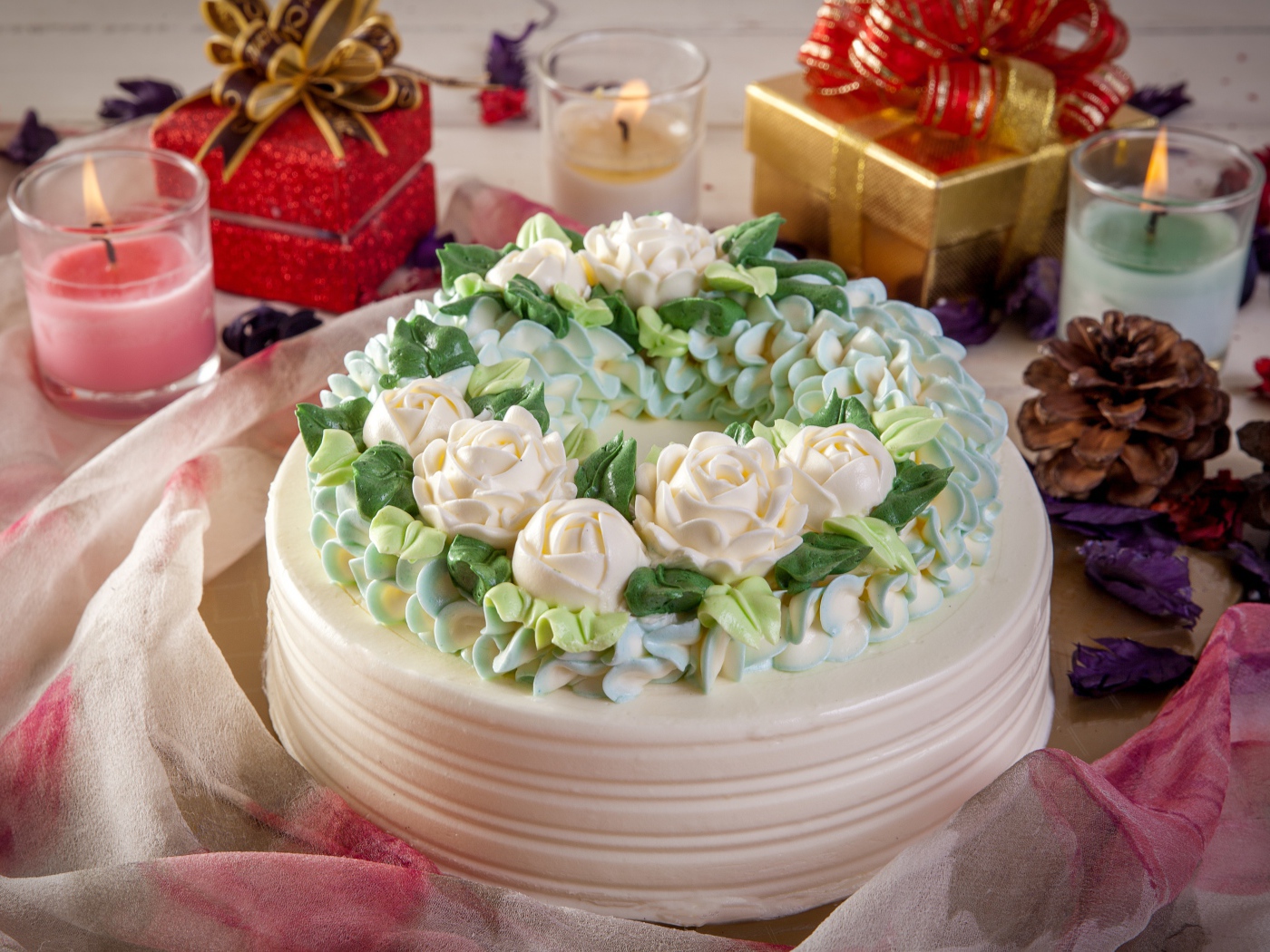 Красивый праздничный торт на столе с подарками и свечами