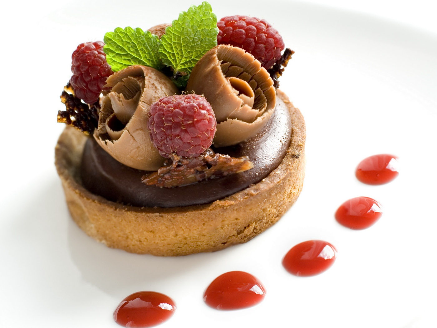 Пирожное с шоколадом и ягодами малины на белом фоне