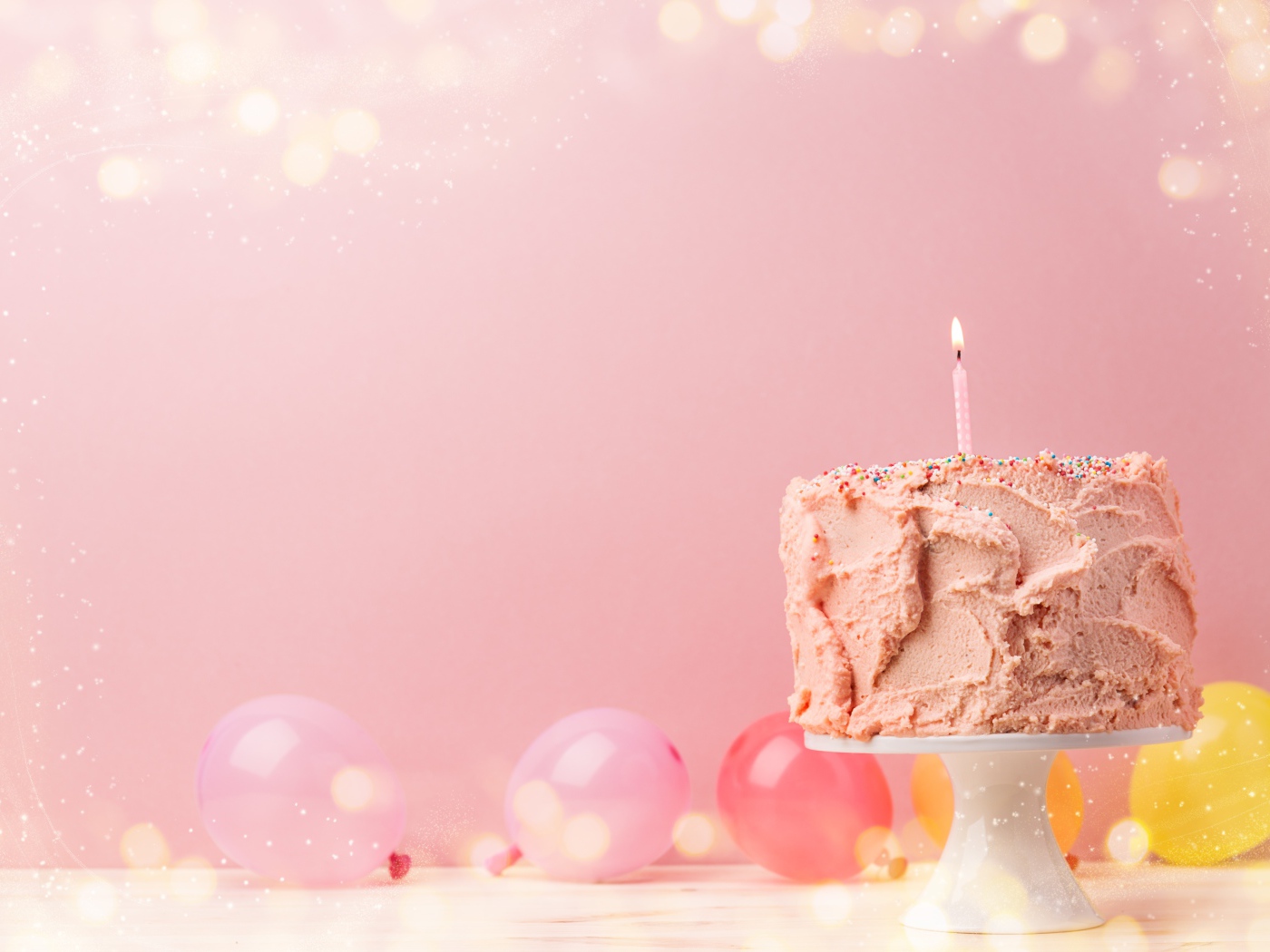 Праздничный торт с воздушными шарами на розовом фоне