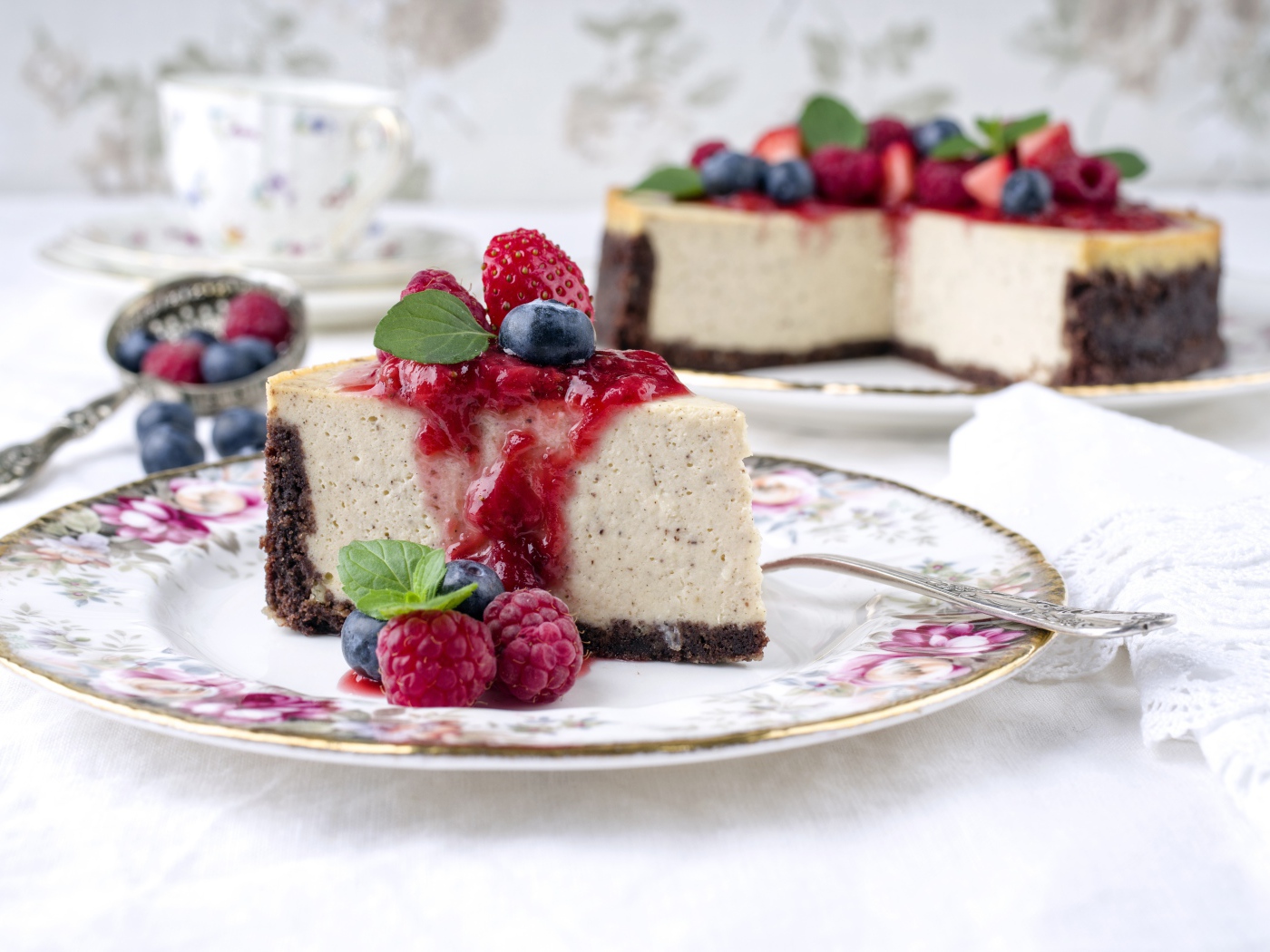 Чизкейк на столе с ягодами малины, черники и клубники