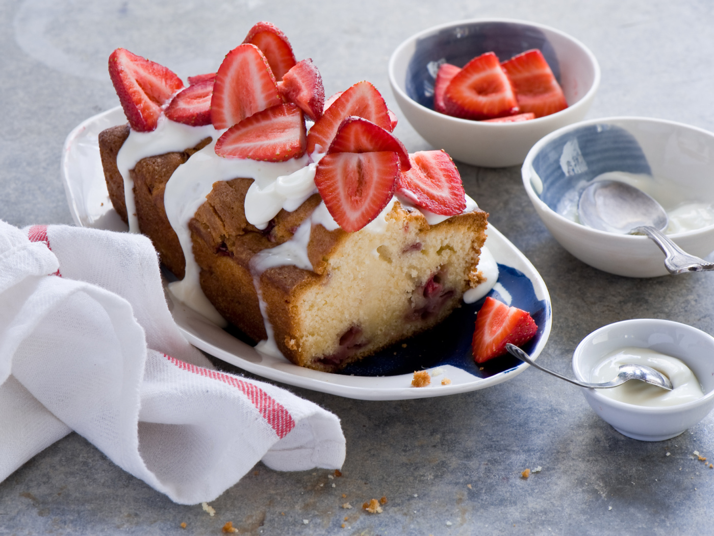 Кекс с кремом на тарелке со свежей клубникой 