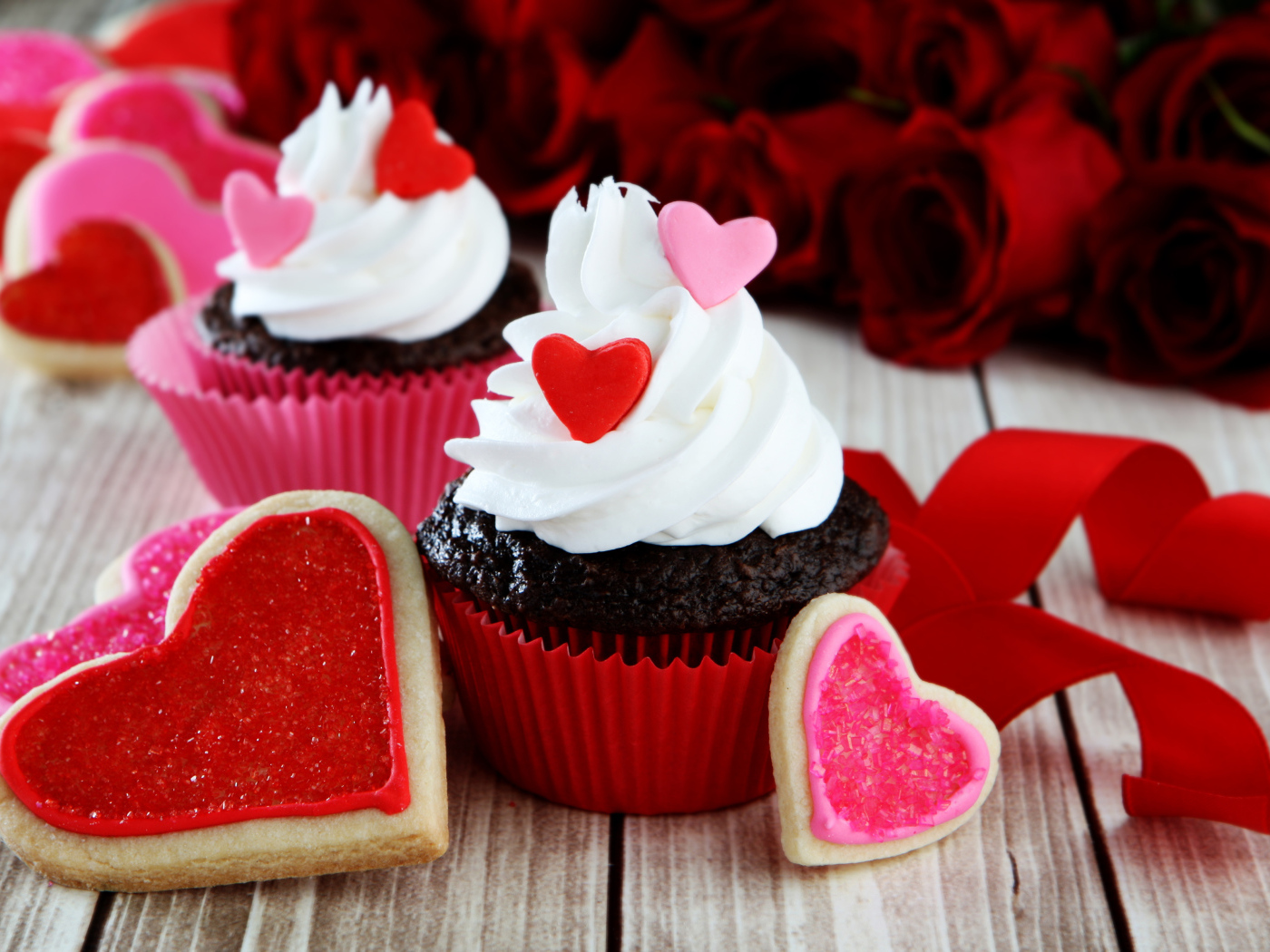 Капкейки с кремом и печенье в форме сердечек на столе