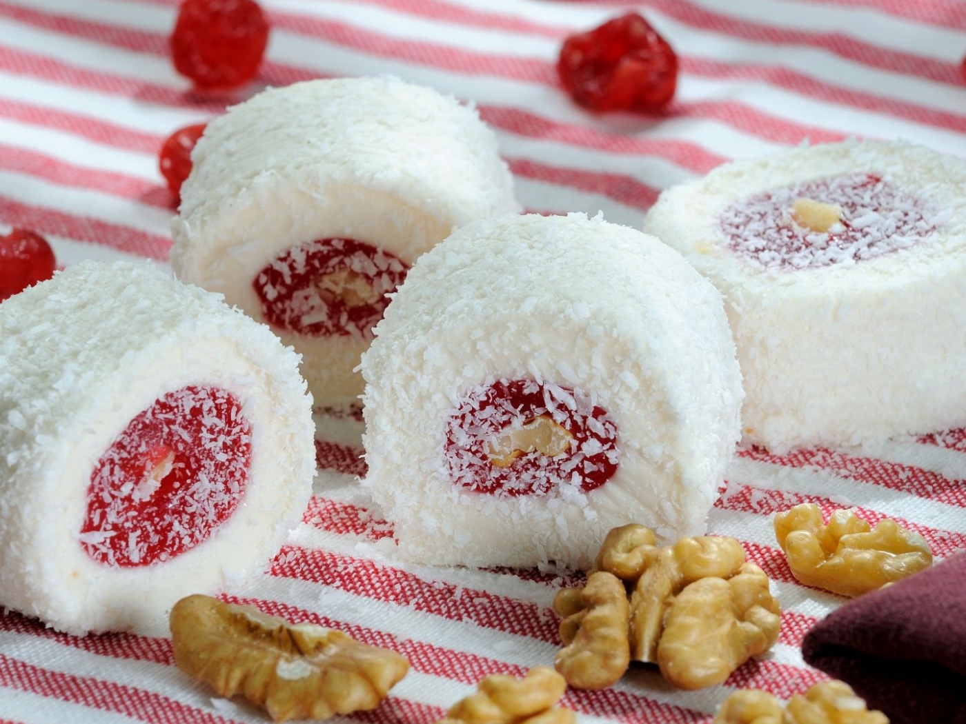 Десерт с джемом и кокосовой стружкой на столе с орехами