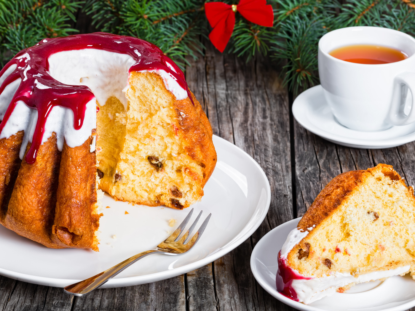 Праздничный кекс с глазурью на столе с чашкой чая