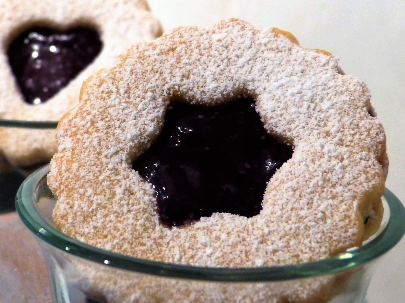 Фигурные печенья с джемом посыпанные сахарной пудрой 