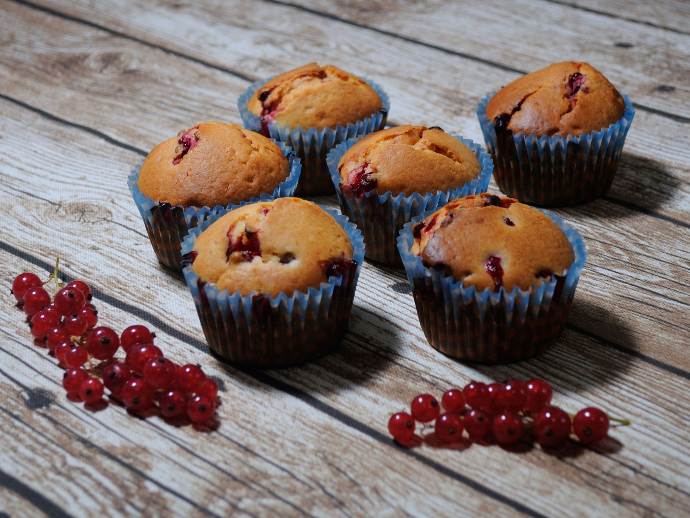 Свежие кексы с красной смородиной на деревянном столе 