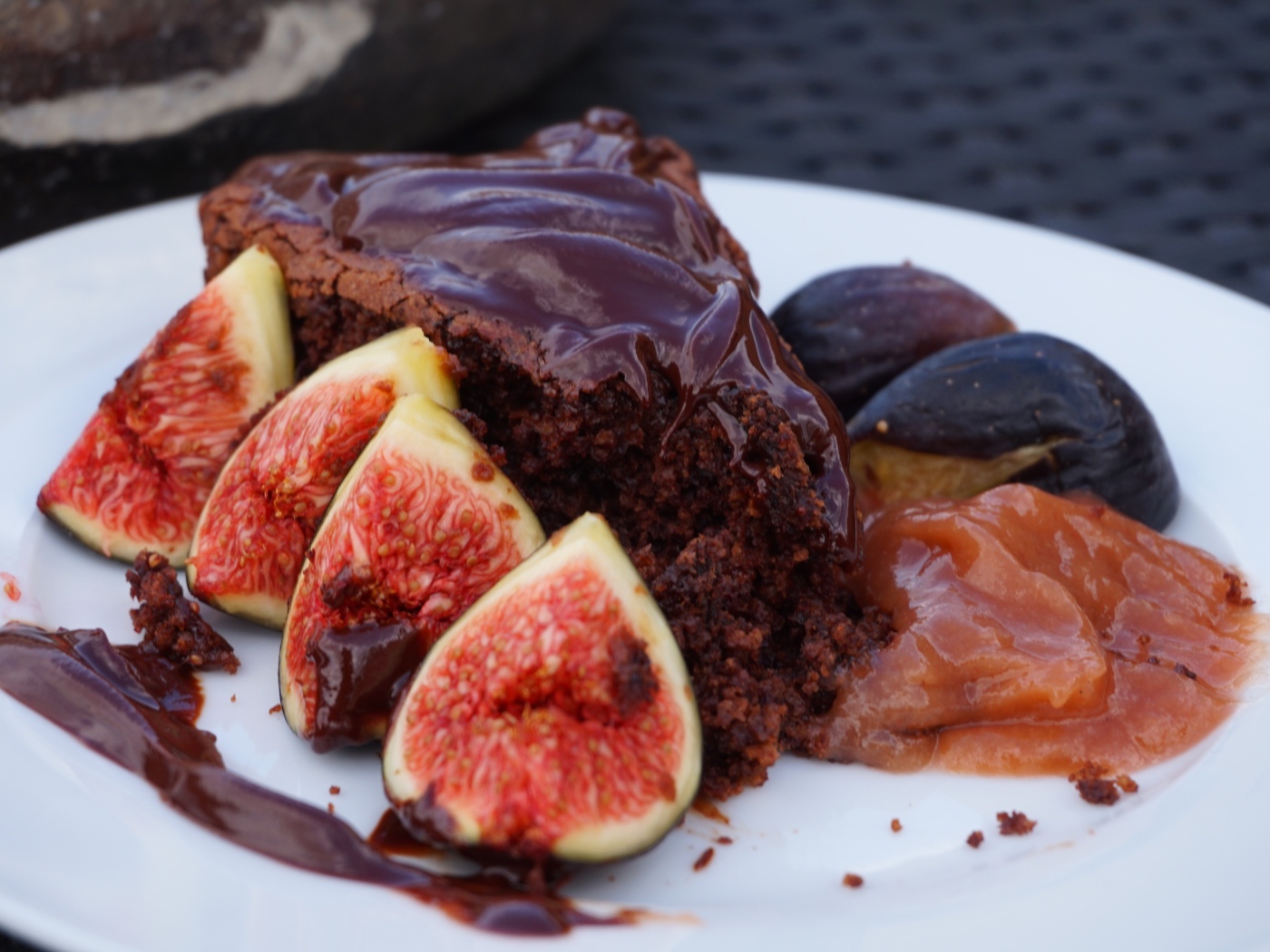 Кусок пирога с шоколадом на тарелке с кусочками инжира