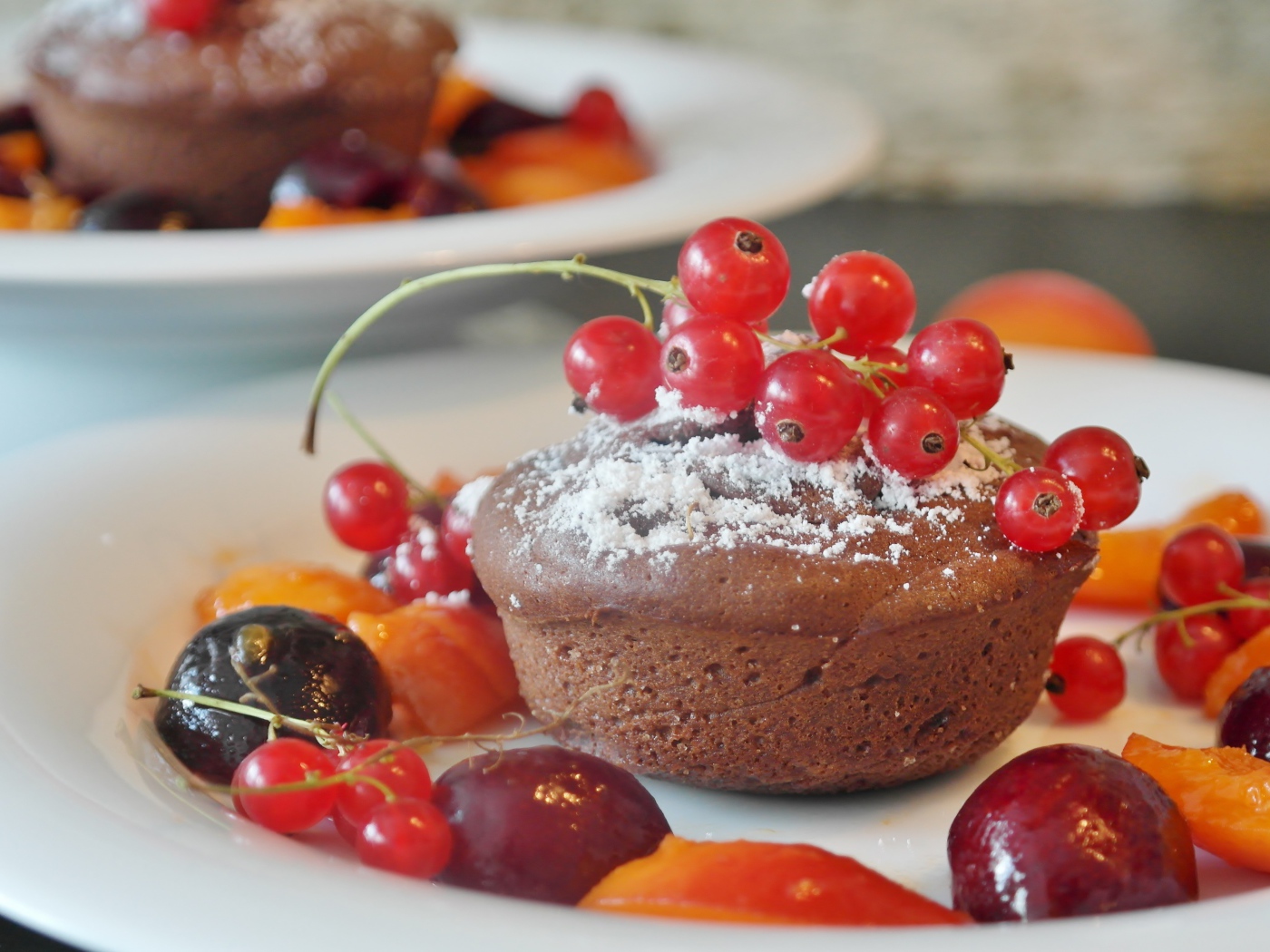 Кексы с красной смородиной на тарелке с ягодами 