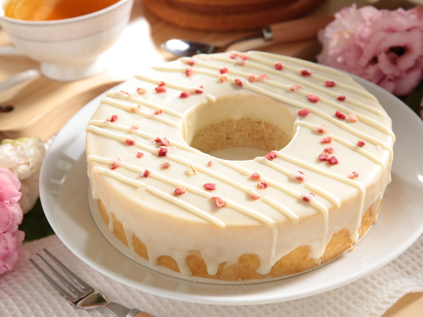 Круглый кекс с глазурью на белом блюде 