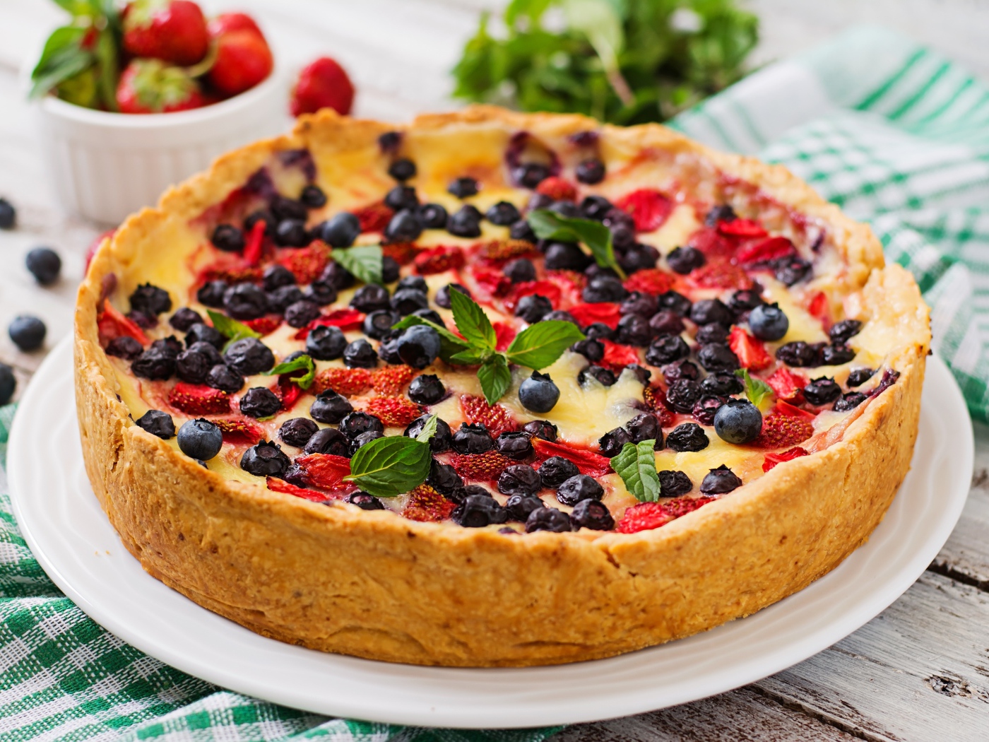 Сладкий пирог с черникой и клубникой на белом блюде