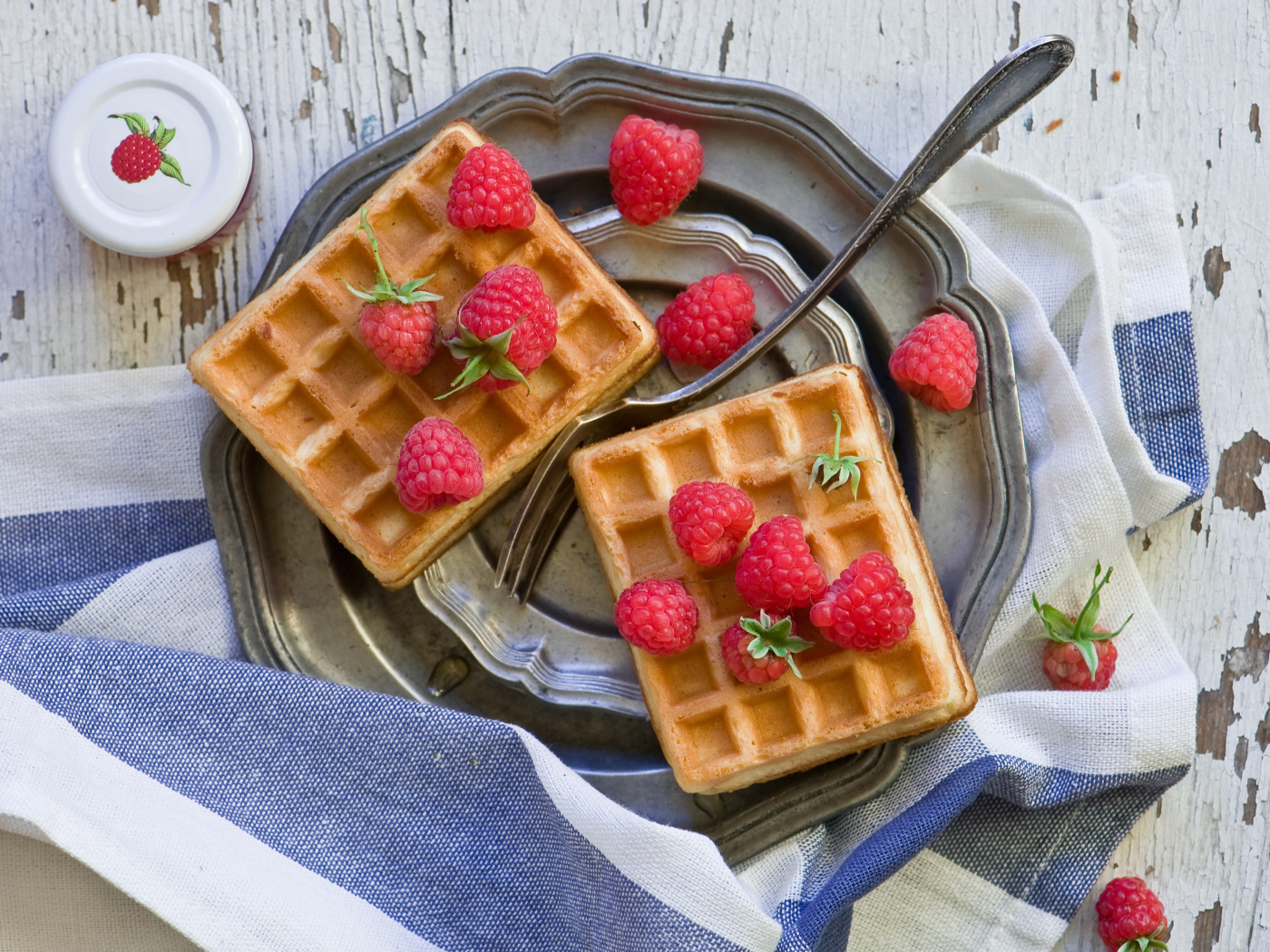 Сладкие вафли с ягодами малины на столе 