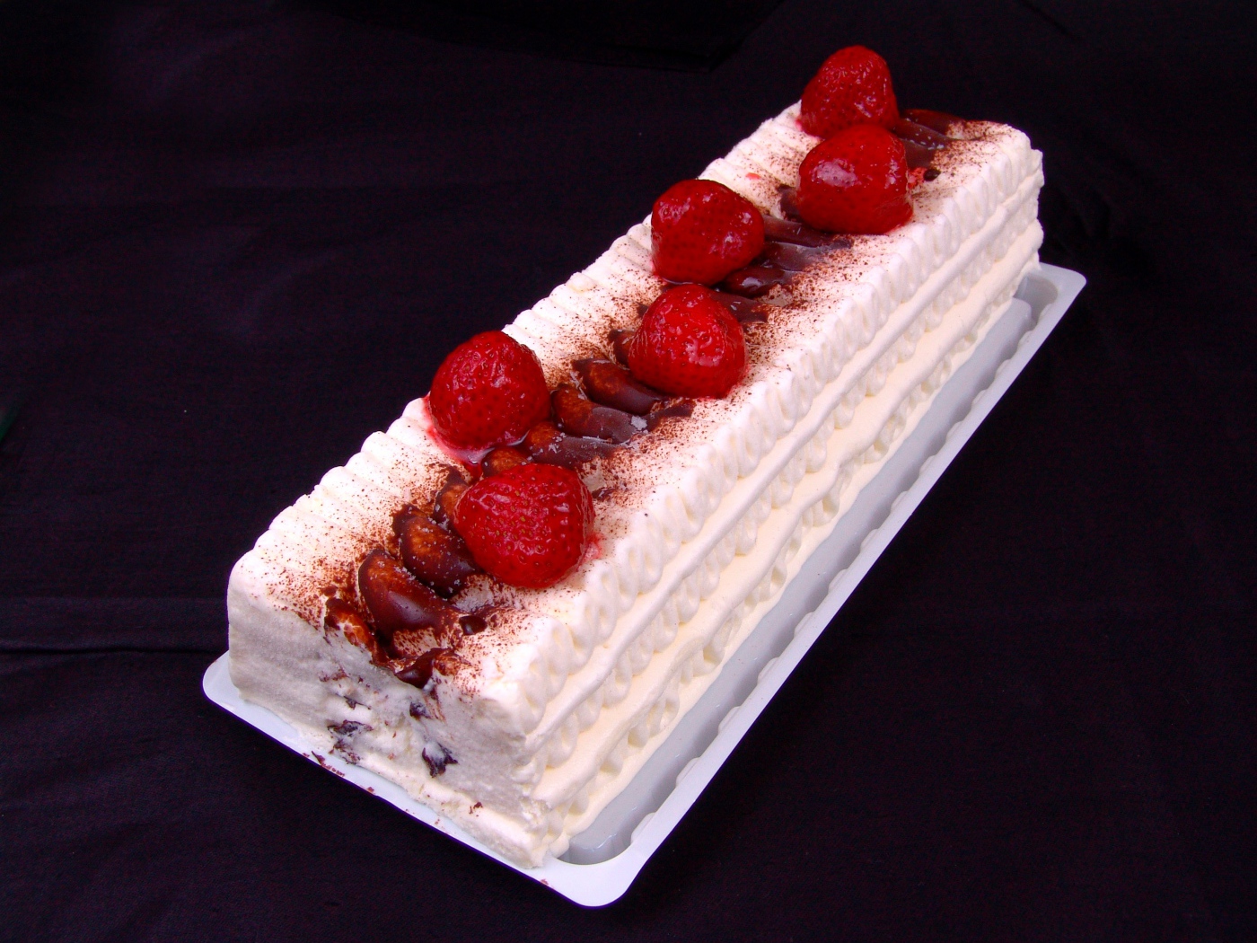 Белый торт с клубникой на черном фоне