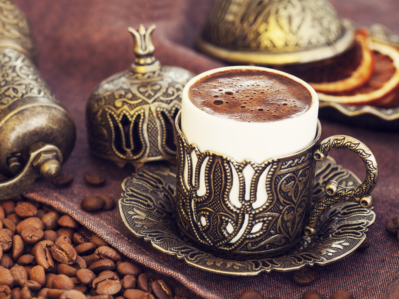 Красивая дизайнерская чашка кофе на столе с зернами