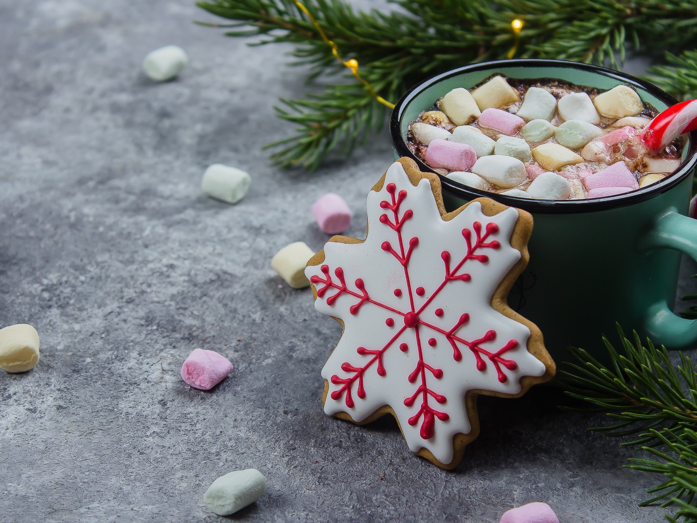 Чашка горячего напитка с кусочками маршмеллоу на столе с печеньем 