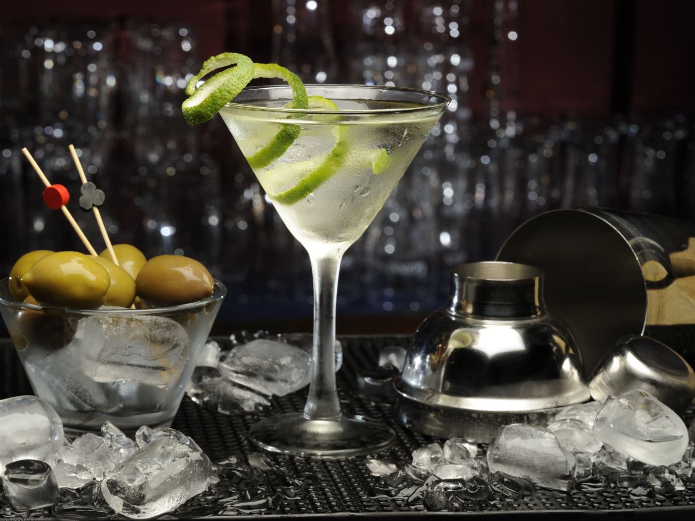 Коктейль с лаймом на столе с оливками и кубиками льда