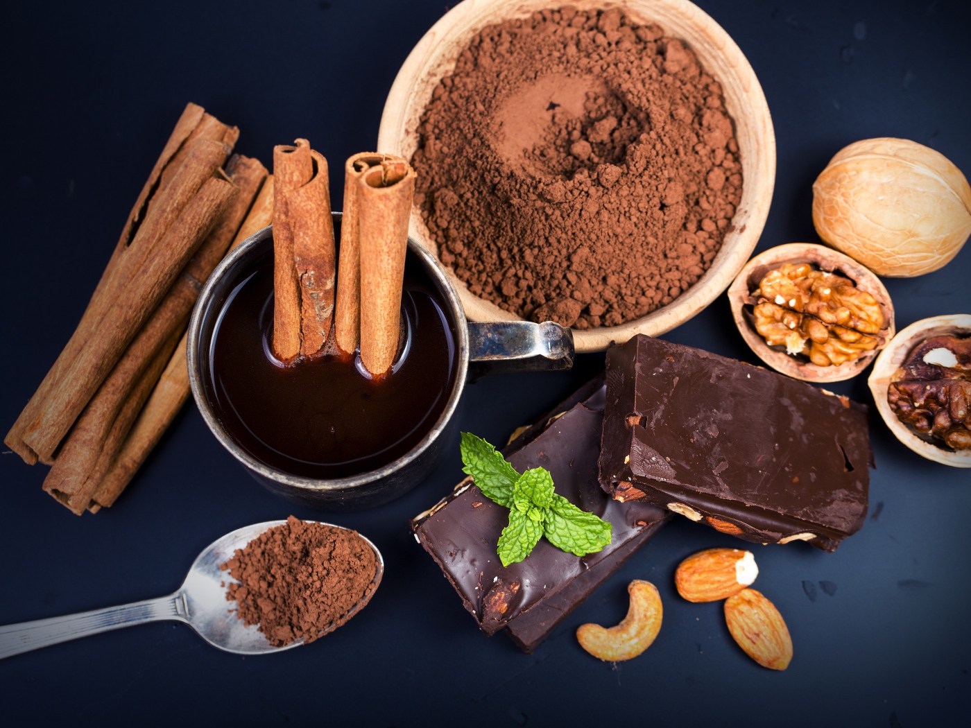 Какао с корицей, орехами и шоколадом на столе 