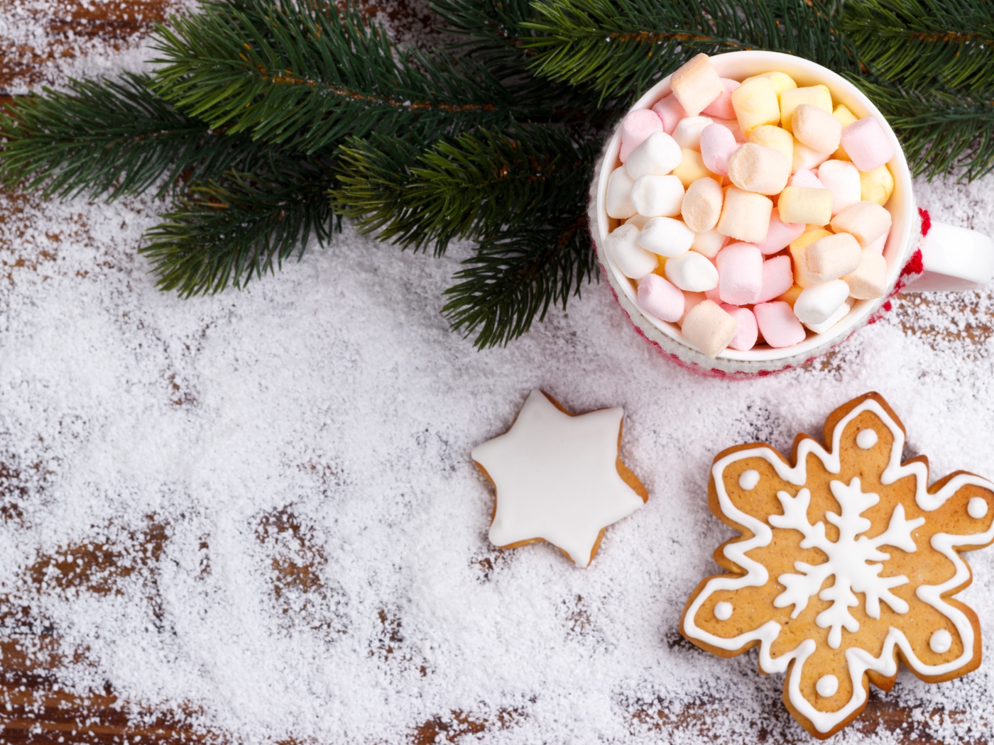 Чашка с маршмеллоу на столе с печеньем и еловой веткой 