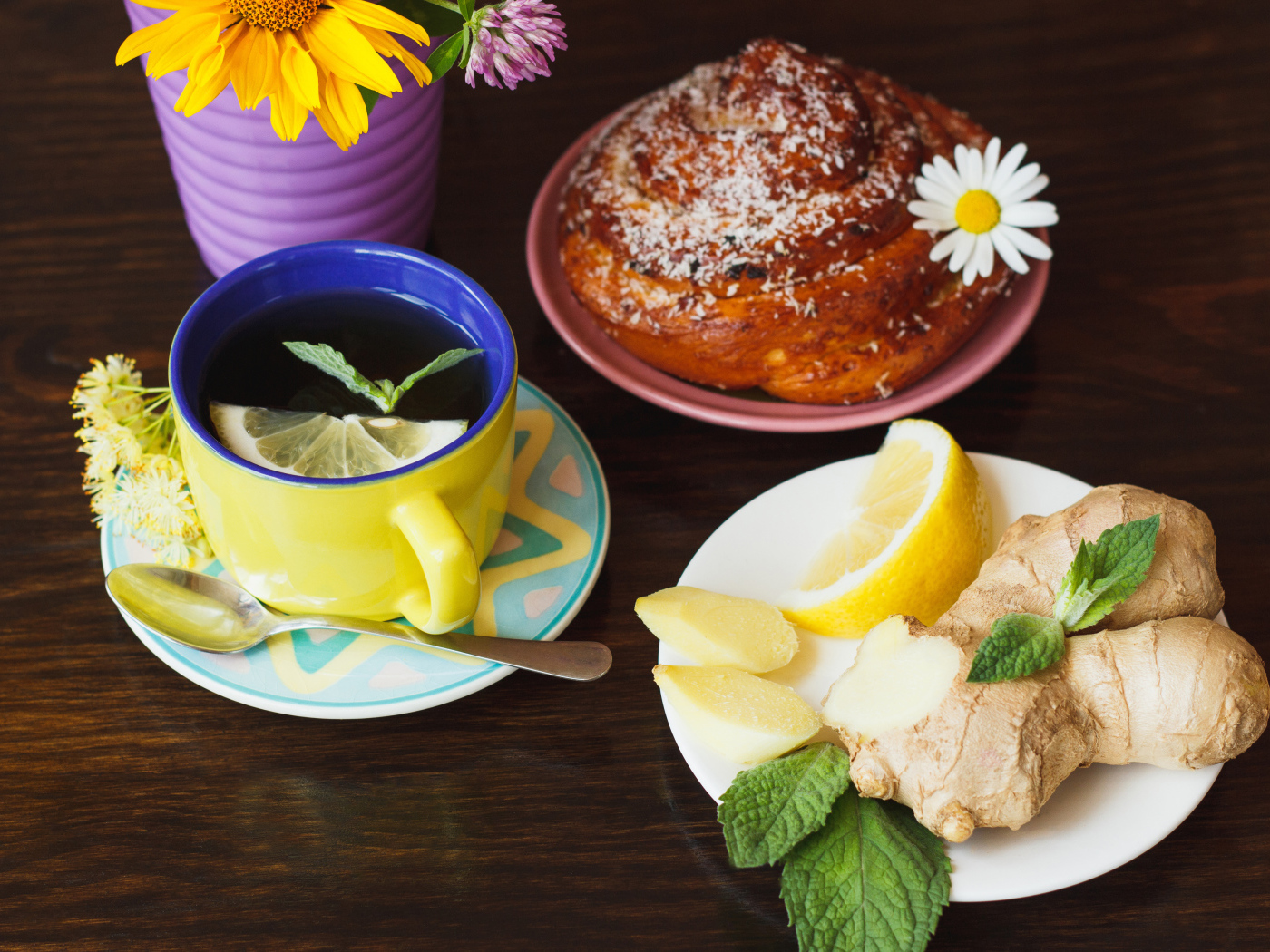 Липовый чай с имбирем и лимоном на столе со свежей булочкой