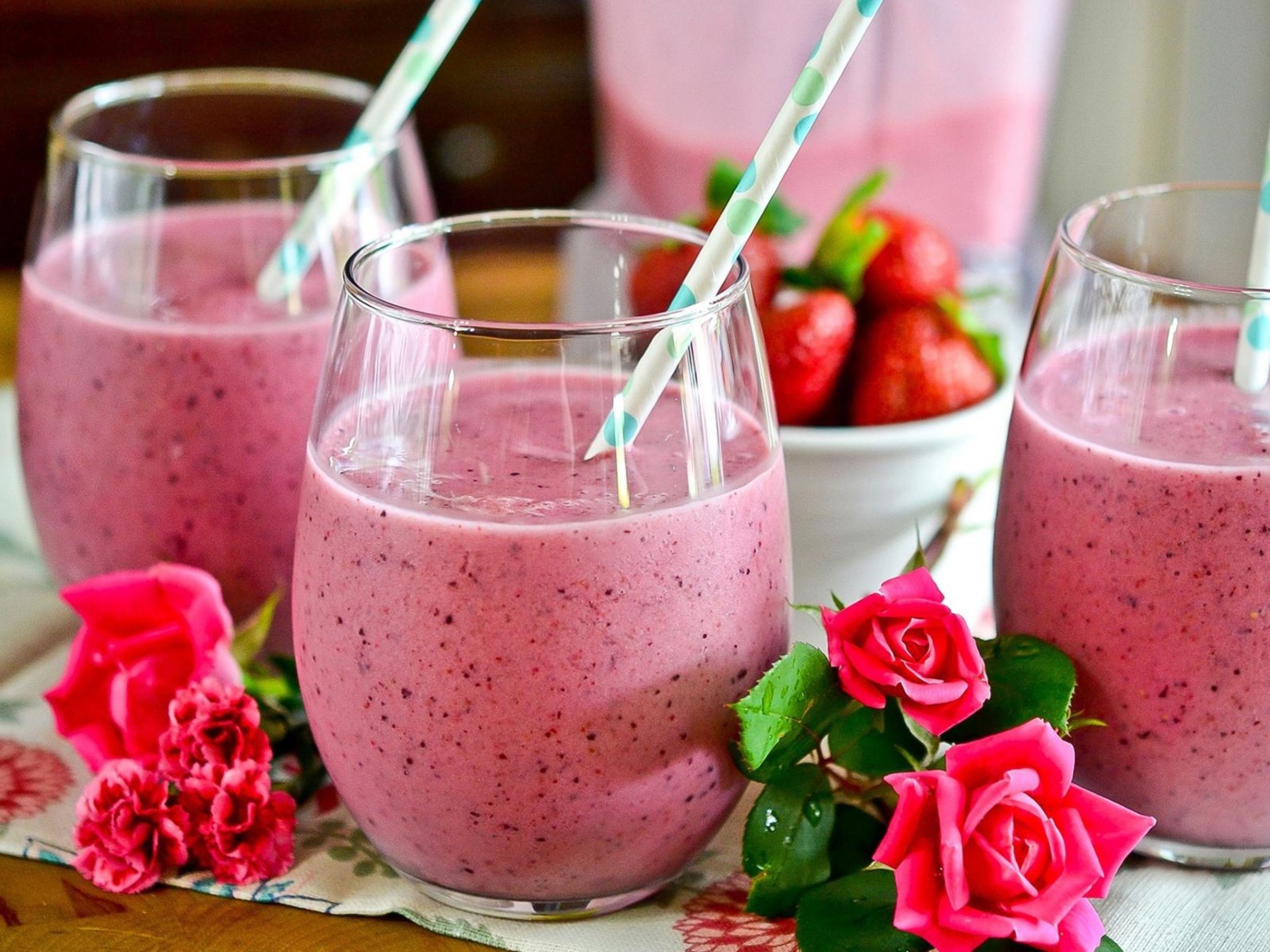Клубничный смузи в стаканах с трубочками на столе