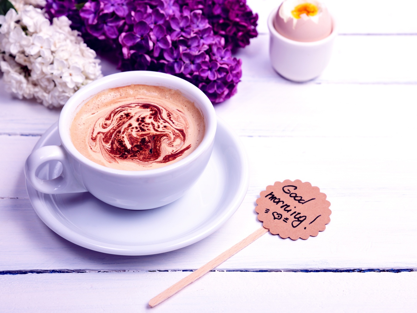 Белая чашка кофе с цветами сирени и яйцом на завтрак