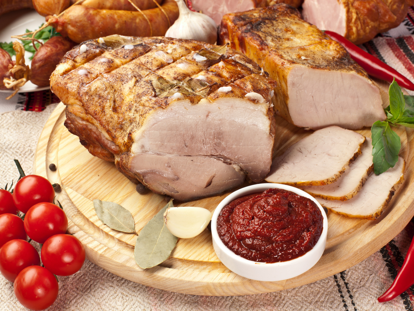 Аппетитная ветчина на столе с соусом и помидорами