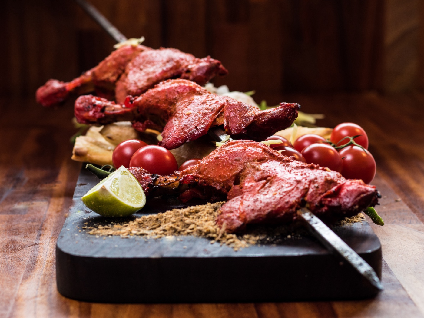 Курица жареная на шампурах на столе с овощами 